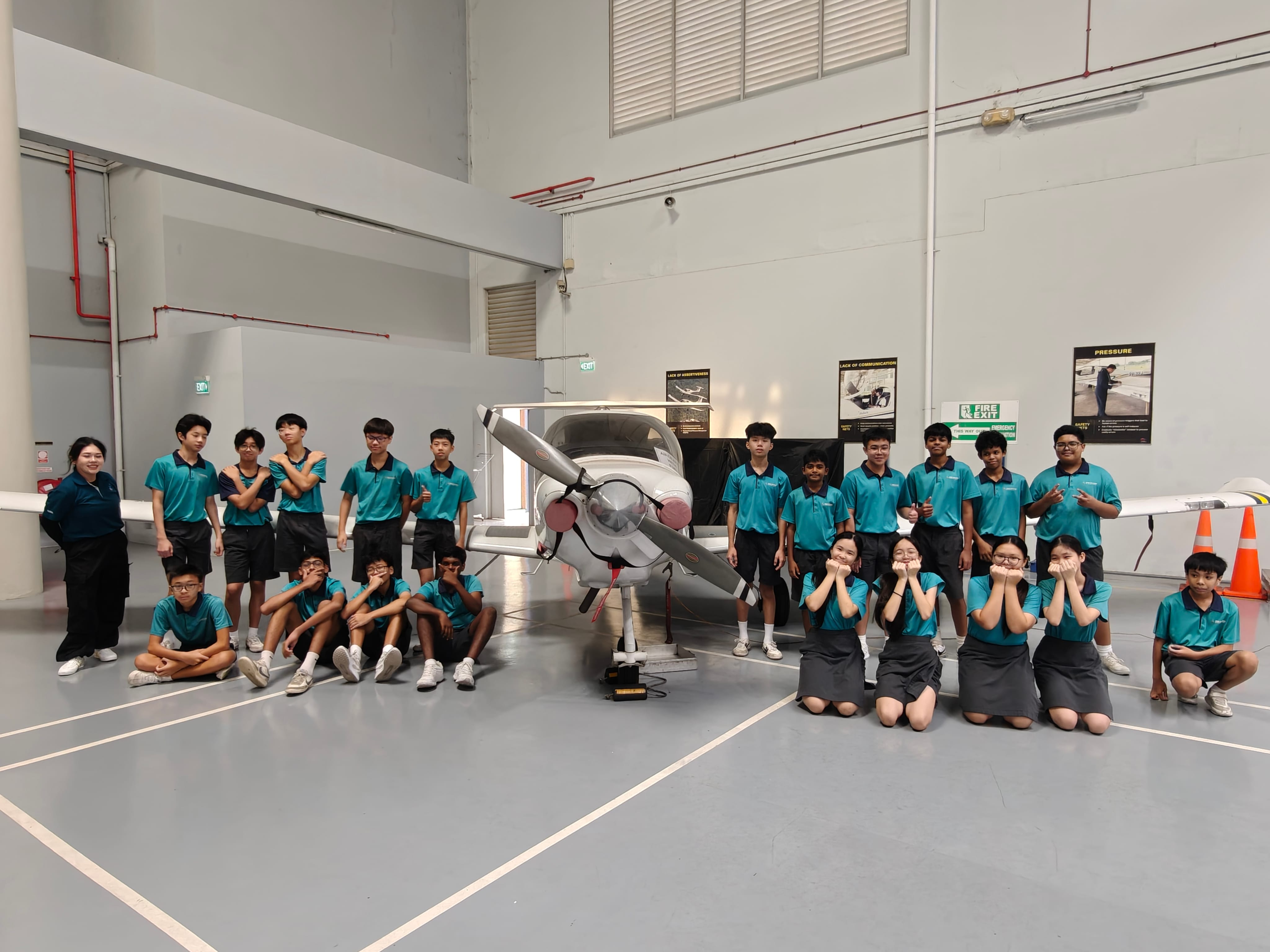 students posing with a plane